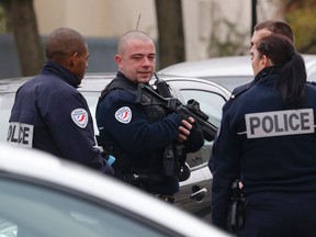 Police officers patrol near a preschool, after a masked assailant with a box-cutter and scissors who mentioned the Islamic State group attacked a teacher in Paris suburb Aubervilliers, on Dec.14, 2015. (AP Photo/Michel Euler)