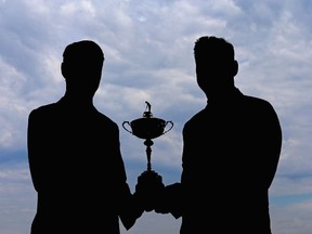 (L-R) A silhouette of Davis Love III, US Ryder Cup Captain and Darren Clarke, European Ryder Cup Captain, as they pose with the trophy during the 2016 Ryder Cup Captains' Photoshoot at Hazeltine National Golf Club on September 28, 2015 in Chaska, Minnesota.   Andrew Redington/Getty Images/AFP
