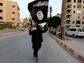 A member loyal to the Islamic State in Iraq and the Levant (ISIL) waves an ISIL flag in Raqqa in this June 29, 2014 file photo.  REUTERS/Stringer