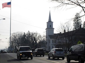 In this Friday, Dec. 11, 2015 photo, the American flag flies over the centre of Newtown, Conn. Monday is the third anniversary of the shooting at Sandy Hook Elementary School that killed 20 first-graders and six educators. Monday is also the first time the anniversary falls on a school day. (AP Photo/Dave Collins)