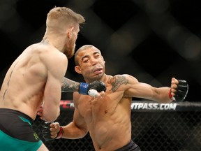 Conor McGregor, left, knocks out Jose Aldo during their featherweight championship bout at UFC 194, Saturday, Dec. 12, 2015, in Las Vegas. (AP Photo/John Locher)
