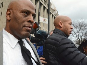 Chicago Police Cmdr. Glenn Evans, left,who was accused of shoving his gun down a suspect's throat and pressing a stun gun to the man's groin in 2013, leaves the Criminal Courts Building in Chicago on Monday, Dec. 14, 2015, after being acquitted on battery and misconduct charges. (Brian Jackson/Chicago Sun-Times via AP)