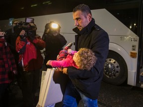 Syrian refugees arrive by bus to a hotel on Dixon Rd. near Toronto Pearson International Airport in Toronto in this file photo. Ernest Doroszuk/Postmedia Network