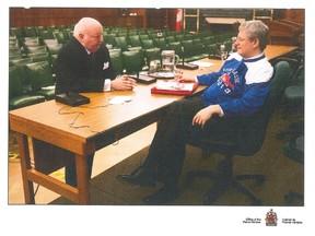 Senator Mike Duffy and former prime minister Stephen Harper are shown at a February 2012 caucus meeting in a handout photo that was entered as evidence at the Duffy trail on Tuesday, Dec. 15, 2015. THE CANADIAN PRESS/HO