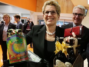 Premier Kathleen Wynne picks up some beer at Loblaws in Toronto on Tuesday, December 15, 2015.  The province has started the sale of beer in grocery stores. (Craig Robertson/Toronto Sun)