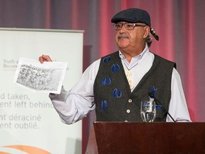 Residential school survivor Eugene Arcand holds up a picture of his classmates at a residential school as he speaks at the release of the final report of the Truth and Reconciliation commission, Tuesday, Dec. 15, 2015 in Ottawa. THE CANADIAN PRESS/Adrian Wyld