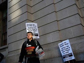 Protester Jonathan Brown stands outside a courthouse as a jury inside deliberates on the case of William Porter, one of six Baltimore city police officers charged in connection to the death of Freddie Gray, Tuesday, Dec. 15, 2015, in Baltimore. (AP Photo/Patrick Semansky)