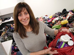 Ottawa Police Const. Sylvie Reaney poses with one of the hundreds of donated purses packed with feminine hygiene products at the Elgin St. police station on Tuesday, Dec. 15, 2015.MATT DAY/OTTAWA SUN