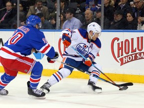 Oilers forward Taylor Hall keeps the puck away from New York Rangers center J.T. Miller during the second period of Tuesday's game in New York. (USA TODAY SPORTS)