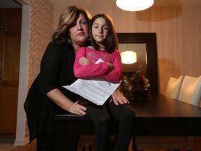 Christine Charbonneau and her daughter Isabel pose for a photo in their home in Ottawa Tuesday Dec. 15, 2015. Isabel has been suspended from her school because the school board says that her immunization records are not up to date. Tony Caldwell/Ottawa Sun/Postmedia Network