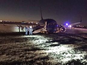 Emergency personnel standby a Southwest Airlines plane that rest on the ground after skidding off the runway at Nashville International Airport, Tuesday, Dec. 15, 2015, in Nashville, Tenn. Officials say three people were injured. (Carson O'Shoney via AP)