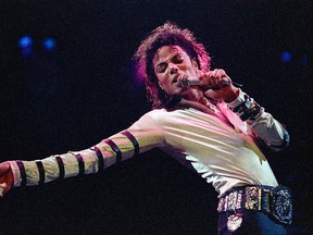 In this Feb. 24, 1988 file photo, Michael Jackson leans, points and sings, dances and struts during the opening performance of his 13-city U.S. tour, in Kansas City, Mo.  (AP Photo/Cliff Schiappa, File)