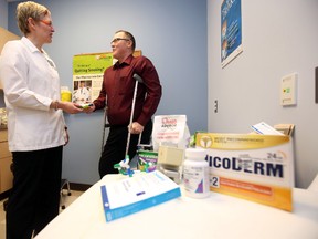 Pharmacist Rami Chowaniec (l) instructs patient Dave Chizen on products to help quit smoking in Edmonton, Alberta on December 16, 2015. Researchers from the UofA are examining how to help smokers quit smoking before elective surgery. Perry Mah/Edmonton Sun