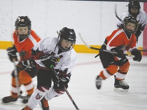 Novice black Hawk Corbin Scobie skates through the Foothills defense during a game Sunday at the Vulcan and District Arena. The novice black Hawks lost 7-4 against Foothills. Photo by Derek Wilkinson Vulcan Advocate