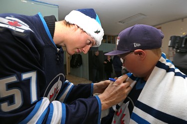 Winnipeg Jets defenceman Tyler Myers signs the scarf of Zach Stewart during a visit to the Rehabilitation Centre for Children on Wellington Crescent in Winnipeg on Wed., Dec. 16, 2015. Kevin King/Winnipeg Sun/Postmedia Network