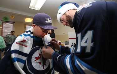 Winnipeg Jets forward Anthony Peluso signs the scarf of Zach Stewart during a visit to the Rehabilitation Centre for Children on Wellington Crescent in Winnipeg on Wed., Dec. 16, 2015. Kevin King/Winnipeg Sun/Postmedia Network