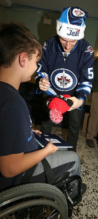 Winnipeg Jets defenceman Tyler Myers signs the tuque of Luke Armbruster, 12, during a visit to the Rehabilitation Centre for Children on Wellington Crescent in Winnipeg on Wed., Dec. 16, 2015. Kevin King/Winnipeg Sun/Postmedia Network