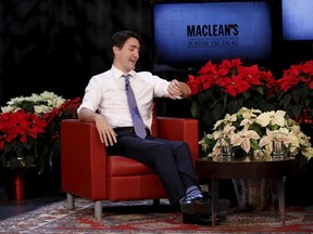 Canada's Prime Minister Justin Trudeau jokingly checks his watch during a Maclean's magazine town hall in Ottawa, Canada, December 16, 2015. REUTERS/Chris Wattie