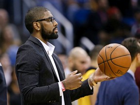 Cleveland Cavaliers guard Kyrie Irving tosses a ball around from the bench area as his teammates take a timeout against the Orlando Magic during a game in Orlando on Dec. 11, 2015. (AP Photo/John Raoux)
