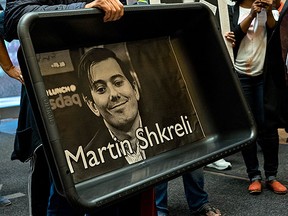 In this Oct. 1, 2015, file photo, activists carry an image of Turing Pharmaceuticals CEO Martin Shkreli in New York, during a protest highlighting pharmaceutical drug pricing. (AP Photo/Craig Ruttle, File)
