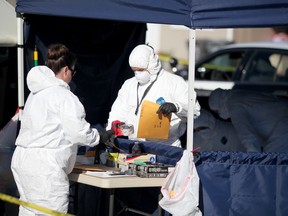 In this Dec. 15, 2015 photo released by the Monterey County Weekly, Salinas Police Crime Scene Investigation technicians bag up evidence at a house in Salinas, Calif., recently lived in by a woman and teenage boy arrested on suspicion of felony child abuse, torture and mayhem. Homicides detectives were investigating Tuesday after authorities found two children dead inside a commercial storage unit in Quincy, Calif., over 300 miles north of Salinas. (Nic Coury/Monterey County Weekly via AP)