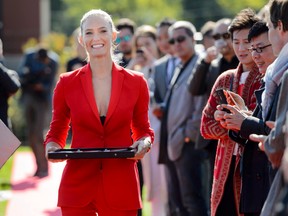 Israeli model Bar Refaeli brings the scissors for the ribbon cutting ceremony during the inauguration ceremony of an extension of the manufacture of the Swiss luxury watchmaker Hublot, owned subsidiary of France's LVMH, in Nyon, Switzerland, Tuesday, Sept. 29, 2015. (Laurent Gillieron/Keystone via AP)