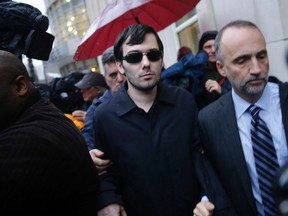 Martin Shkreli, center, leaves the courthouse after his arraignment in New York, Thursday, Dec. 17, 2015. Shkreli, the former hedge fund manager vilified in nearly every corner of America for buying a pharmaceutical company and jacking up the price of a life-saving drug more than fiftyfold, was arrested Thursday on securities fraud charges unrelated to the furor. (AP Photo/Seth Wenig)