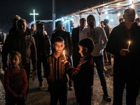 Alice Martins/The Associated Press
In this Dec. 1 photo, Iraqi Christians hold candles at a camp for the displaced in Irbil, northern Iraq, as they await the arrival of a convoy carrying the bodies of seven family members who drowned as they attempted to cross the Aegean Sea to Europe. They had fled Islamic State militants from their home on the plains of Nineveh last year and lived in the IDP camp in Irbil since. The members of the family who died on Nov. 17 were identified as 31-year-old Steven Marzina, a baker, his wife, 27-year-old Silvana, and their children, Ingi, 4, and Mark, 7.