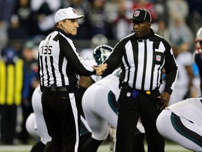 Referee Peter Morelli, left, and umpire Ruben Fowler confer during the first half of an NFL football game between the New England Patriots and the Philadelphia Eagles, Sunday, Dec. 6, 2015, in Foxborough, Mass. (AP Photo/Charles Krupa)