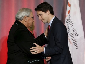 Canada's Prime Minister Justin Trudeau (R) shakes hands with Justice Murray Sinclair during the release of the Truth and Reconciliation Commission's final report in Ottawa, Canada, December 15, 2015. Trudeau pledged to work toward full reconciliation with Canadian Aboriginals on Tuesday as he accepted a final report on the abuses of the government's now-defunct system of residential schools for indigenous children. REUTERS/Chris Wattie