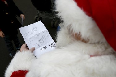Actor John Field, dressed as Santa Claus, reads a Christmas wish list at the Wetland Centre in London, Britain, Dec. 6, 2015.  REUTERS/Stefan Wermuth