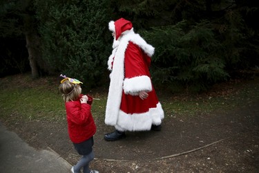 A girl watches as actor John Field, dressed as Santa Claus, walks past at the Wetland Centre in London, Britain, Dec. 5, 2015. REUTERS/Stefan Wermuth