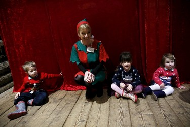 (L-R) Five-year-old Cian McKenna waits with his siblings Sophie and Esme to meet actor John Field at a Christmas grotto at the Wetland Centre in London, Britain, Dec. 5, 2015. REUTERS/Stefan Wermuth