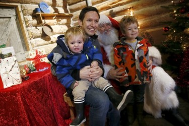 (L-R) Two-year-old Jasper Richards, his father George and his four-year-old brother Sebastian, pose with actor John Field, dressed as Santa Claus, at a Christmas grotto at the Wetland Centre in London, Britain, Dec. 5, 2015. REUTERS/Stefan Wermuth