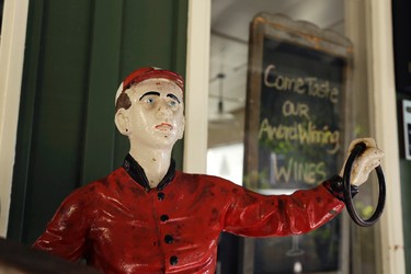 In this photo taken Thursday, Nov. 5, 2015, a statue of a jockey stands outside a wine tasting room along "Ark Row" in Tiburon, Calif. Many of the scenic "Ark Row" shops are actually housed in turn of the century boat houses that were converted into homes and shops. (AP Photo/Eric Risberg)