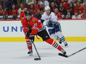 Chicago Blackhawks center Marcus Kruger skates past Vancouver Canucks center Henrik Sedin during the first period at the United Center on Dec. 13, 2015. (Dennis Wierzbicki/USA TODAY Sports)