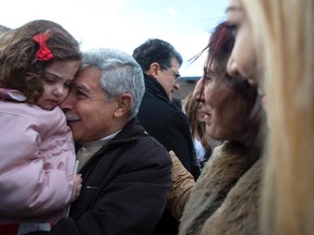 Hagop Karageozian, centre left, meets his granddaughter Rita Mahserjian for the first time as his wife Elo Manushian and daughter Maria Karageozian, right, watch as Syrian refugees arrive at the Armenian Community Centre, in Toronto, on Friday, Dec. 11, 2015. The refugees arrived in the early hours of the morning on the first government-arranged flight to land at Toronto's Pearson Airport. THE CANADIAN PRESS/Chris Young