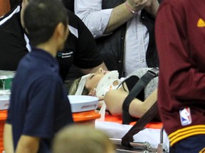 Ellie Day, wife of PGA Tour golf player Jason Day, is carried off the floor in a stretcher after Cleveland Cavaliers' LeBron James collided with her out of bounds in a game against the Oklahoma City Thunder in Cleveland on Dec. 17, 2015. (John Kuntz/The Plain Dealer via AP)