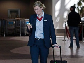 FILE - An Air Canada flight attendant walks through the terminal at the Halifax airport on Sept. 20, 2011. Air Canada and CUPE say the airline's flight attendants have approved a 10-year agreement reached with the carrier last month.The union said in a statement that the agreement was accepted by a narrow margin, but did not provide a voting margin. (The Canadian Press/Andrew Vaughan)