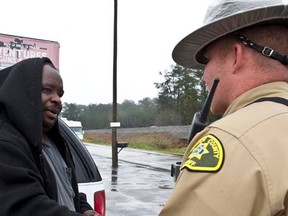 Monroe County sheriff's Deputy Timothy Campfield, right, shakes hands with James King after Campfield gives King a $100 bill. (Photo is a screengrab from macon.com/ WOODY MARSHALL)
