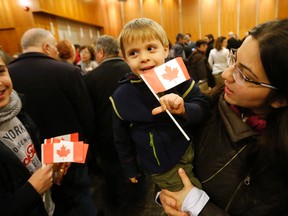 Zawenawedian Dawdian, 2, is held by his mother Mario and was one of a group of sponsored Syrian refugees who arrived in Toronto on Dec. 16, 2015. (Michael Peake/Toronto Sun)