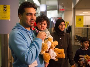 A family of Syrian refugees arrive at the Welcome Centre at Toronto's Pearson Airport on Friday December 18, 2015. (The Canadian Press/Chris Young)