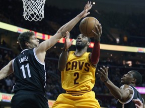 Cleveland Cavaliers guard Kyrie Irving (2) scores between Brooklyn Nets centre Brook Lopez (11) and forward Thaddeus Young (30) at Quicken Loans Arena. (Ron Schwane/USA TODAY Sports)