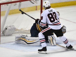 Chicago Blackhawks winger Patrick Kane puts the puck past Buffalo Sabres goaltender Chad Johnson during a shootout Saturday Dec. 19, 2015 in Buffalo. (AP Photo/Gary Wiepert)