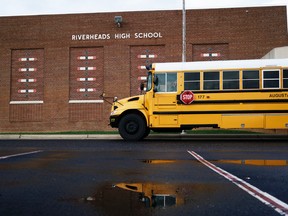 In this Thursday, Dec. 17, 2015 photo, a school bus waits outside of Riverheads High School in Staunton, Va., after Augusta County Schools were placed on lockdown in the afternoon. The closure was prompted by security concerns due to thousands of angry emails and social media postings after a teacher's lesson on Islam at Riverheads High School the previous week. (Griffin Moores/The Staunton News Leader via AP)