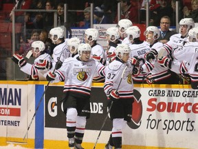 Owen Sound centre Nick Suzuki (right) hi fives the bench after scoring his first goal of the game in the Attack's 4-3 overtime win over the London Knights on Saturday in Ontario Hockey League play.