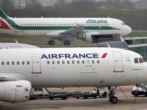 An Alitalia plane passes an Air France plane on the tarmac of Charles de Gaulles International Airport in Roissy near Paris in this January 8, 2013 file photo.  (REUTERS/Charles Platiau)