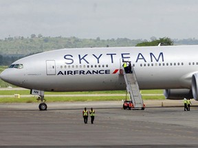 Airport workers are seen near the Air France Boeing 777 aircraft that made an emergency landing is pictured at Moi International Airport in Kenya's coastal city of Mombasa, December 20, 2015. The Air France flight from Mauritius diverted and made an emergency landing at Kenya's port city of Mombasa after a suspicious device was found in a toilet, Kenya's head of police and the airline said on Sunday. (REUTERS/Joseph Okanga)