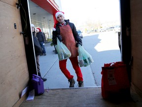 Joey Rufo loads donations into a trailer outside Dewe's grocery store in Belleville during a food drive for Gleaners Food Bank, on Saturday December 19, 2015 in Belleville, Ont. Emily Mountney-Lessard/Belleville Intelligencer/Postmedia Network