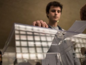 A man casts his vote at a polling station  for the national elections, in Pamplona northern Spain, Sunday, Dec. 20, 2015.  Spaniards are voting in an historic national election Sunday with the country’s traditional two-parties and widely anticipated strong showings for two new parties. (AP Photo/Alvaro Barrientos)